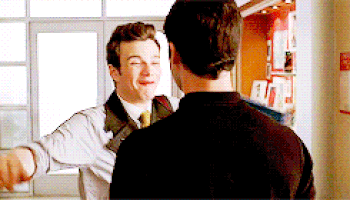 Kurt running and hugging Blaine tightly, smiling broadly.